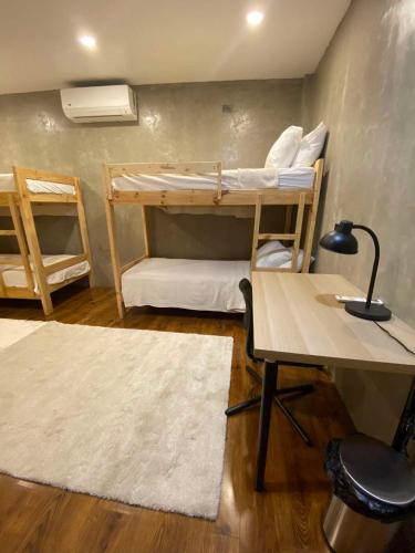 a room with bunk beds and a desk and a table at Alab in Mabini