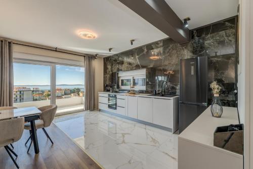 a kitchen with a table and a refrigerator and a counter at Villa La Vie - Podstrana in Podstrana