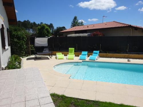 une piscine avec des chaises longues et une piscine dans l'établissement Landaise idéale pour 1 à 2 couples avec enfants, à Azur