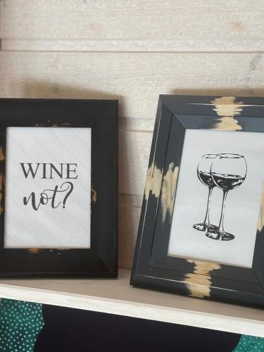a picture of a wine glass next to a framed picture at Cozy studio in a horse ranch in Lieplaukė