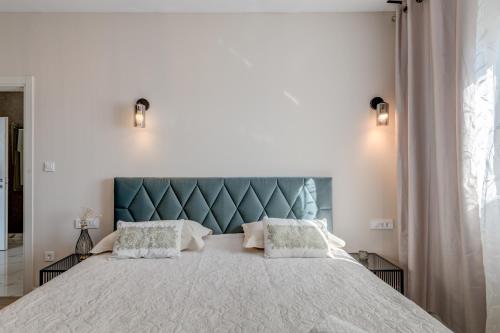a bedroom with a large bed with a blue headboard at Villa La Vie - Podstrana in Podstrana