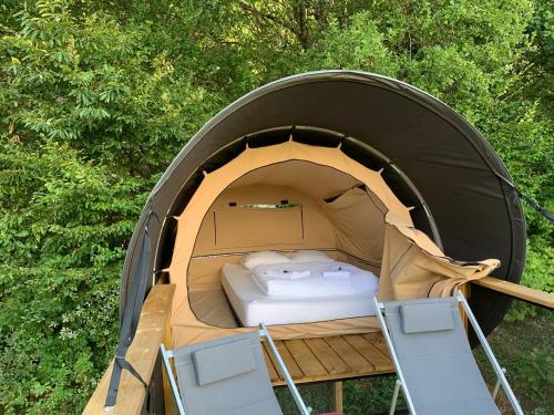 a tent with a bed and chairs in it at Le Village des Monédières in Chamberet