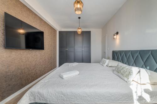 a bedroom with a bed with a tv on the wall at Villa La Vie - Podstrana in Podstrana