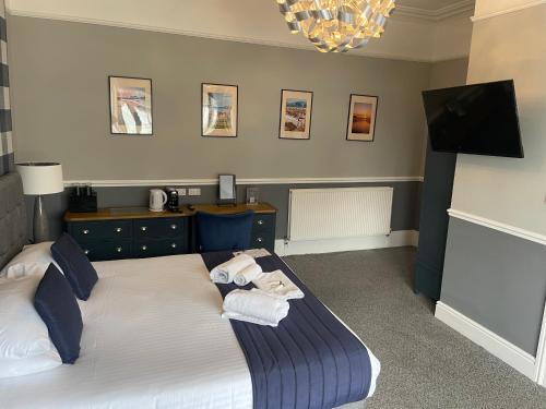 a bedroom with a bed with towels on it at The Wildings Hotel & Tudno's Restaurant in Llandudno