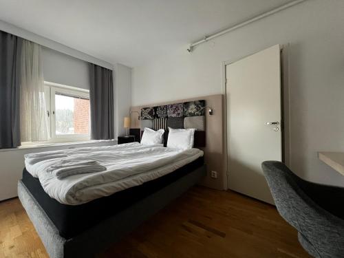a bedroom with a large bed and a window at Injoy Premium Hotel Solna in Solna