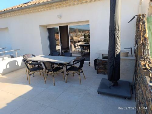 un patio avec une table et des chaises sur un patio dans l'établissement Appartement Design, à La Londe-les-Maures