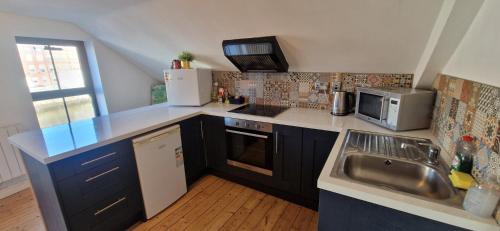 a small kitchen with a sink and a microwave at Spacious Riverside 2Bd Mid City - Above Bar&Venue in Cork