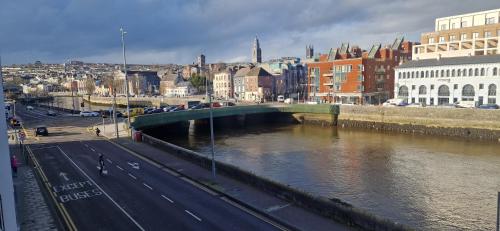 a bridge over a river in a city with buildings at Spacious Riverside 2Bd Mid City - Above Bar&Venue in Cork