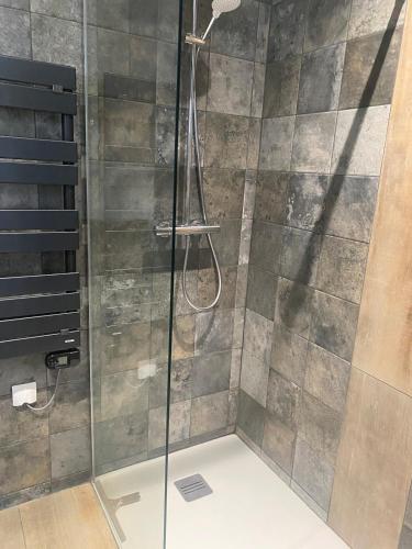 une douche avec une porte vitrée dans une salle de bain dans l'établissement Appartement Design, à La Londe-les-Maures