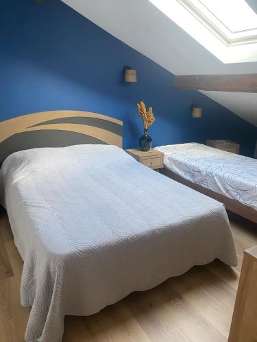 une chambre avec deux lits et un mur bleu dans l'établissement Appartement Design, à La Londe-les-Maures