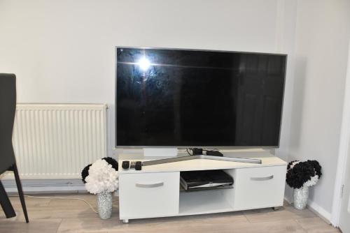 a white entertainment center with a flat screen tv at 2 Bedroom semi-detached house Luton in Luton