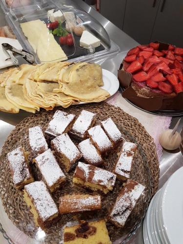 a table with cakes and other desserts on it at Deluxe Dina in Skala Potamias