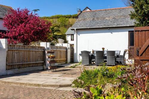 a patio with chairs and a fence and a house at CROYDE BRIAR HOUSE 4 Bedrooms in Croyde