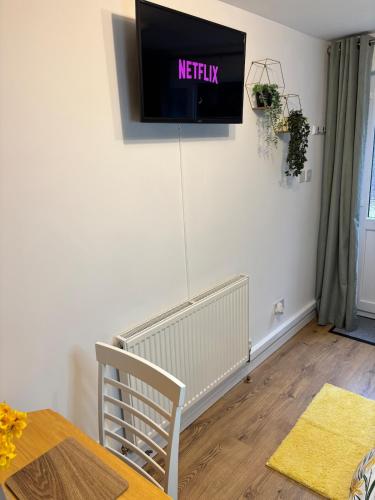 a tv on the wall of a living room at Cosy Studio Near Park and Town in Bromsgrove