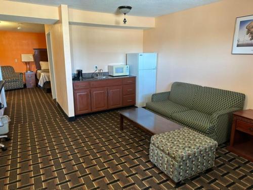 a hotel room with a couch and a microwave at Stay Inn by OYO Near I 80 Lincoln West in Lincoln