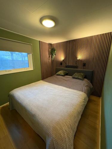 a bedroom with a large bed in a room at HEERLIJK CHALET MIDDENIN DE NATUUR! in Putten