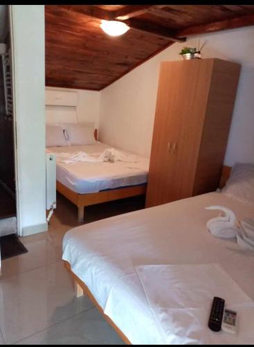 a small room with two beds and a cabinet at Vila Masy in Costinesti