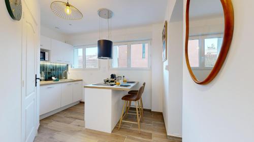 - une cuisine avec un comptoir et un miroir dans l'établissement expat renting - Le Tropical - Netflix - Proche gare, à Toulouse