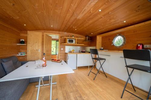 a kitchen and living room with a table and chairs at Le Village des Monédières in Chamberet