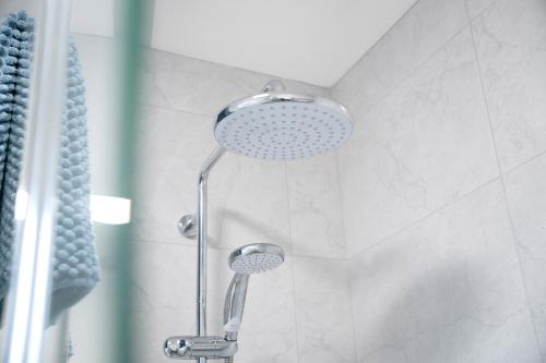 a shower with a shower head in a bathroom at NEW! 3BR in Traynor Square in Catterick Bridge Station