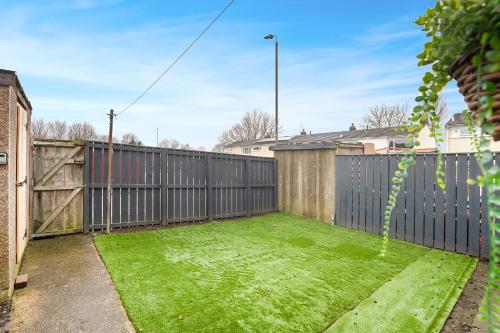 a backyard with a fence and a yard with grass at NEW! 3BR in Traynor Square in Catterick Bridge Station