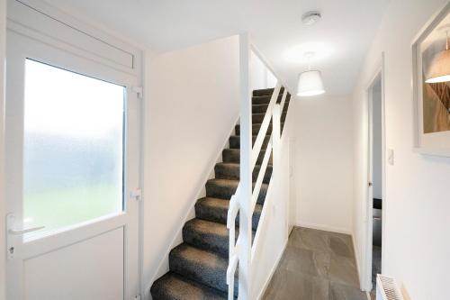 a staircase in a home with white walls and a window at NEW! 3BR in Traynor Square in Catterick Bridge Station