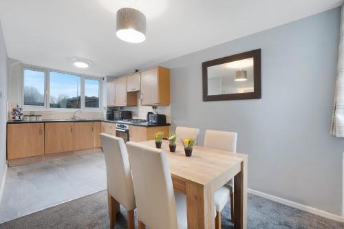 a kitchen with a wooden table and white chairs at NEW! 3BR in Traynor Square in Catterick Bridge Station