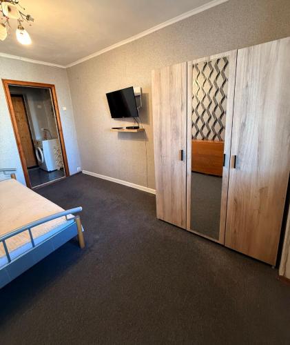 a bedroom with a bed and a tv and cabinets at One Room Apartment in Chişinău