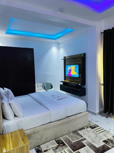 Un dormitorio con una cama grande y un televisor de pantalla plana. en QODE apartments, en Lekki