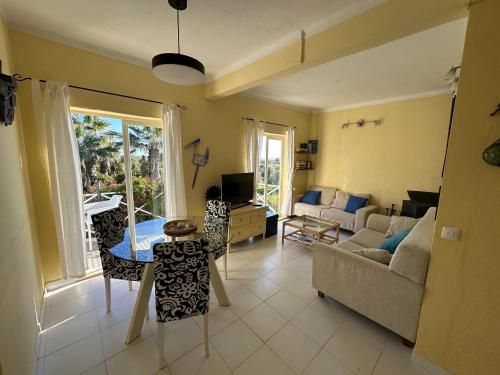 a living room with a couch and a table at Ceu Azul - Elevated apartment with stunning views and big garden - Somewhere Special in Tavira