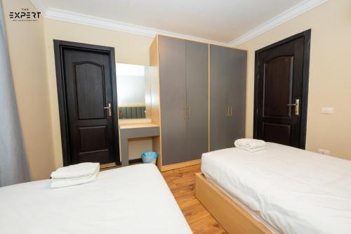 two beds in a room with two closets at The Expert in Ocean Blue Near Airport in Cairo