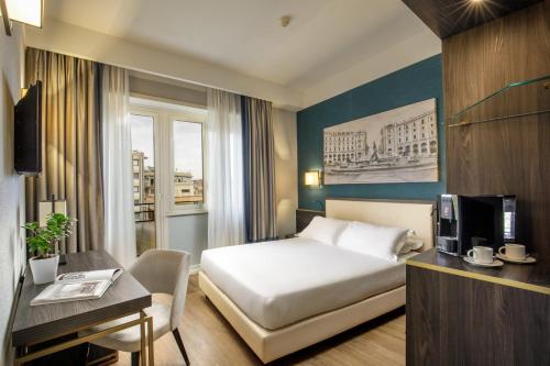 a hotel room with a bed and a desk at Hotel Santa Costanza by OMNIA hotels in Rome