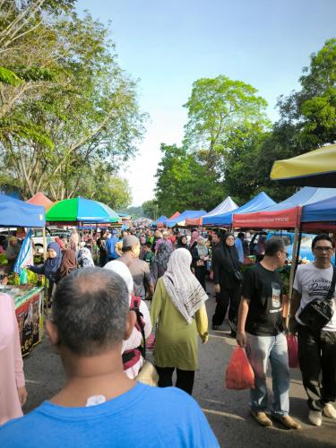 a crowd of people walking around a market with umbrellas at HV SENCHO HOMESTAY House Vessel Sencho Home of Nautical Decoration in Temerloh