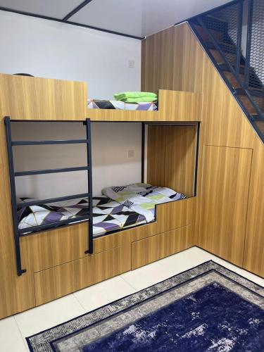 a bunk room with two bunk beds and a staircase at HV SENCHO HOMESTAY House Vessel Sencho Home of Nautical Decoration in Temerloh