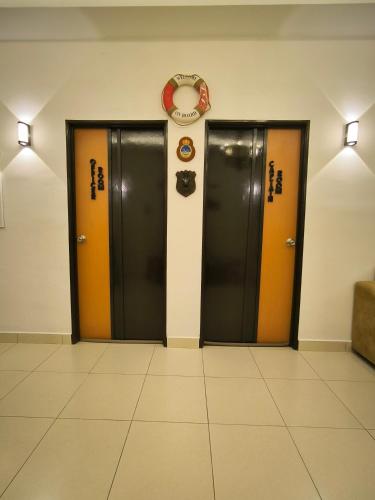 two doors in a hallway with a clock on the wall at HV SENCHO HOMESTAY House Vessel Sencho Home of Nautical Decoration in Temerloh
