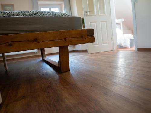 a wooden bench sitting on top of a wooden floor at Faehrmann-s-Huus-Ditzum in Ditzum