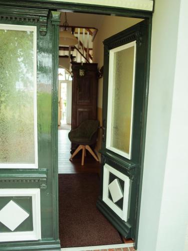 an open door into a room with a chair at Faehrmann-s-Huus-Ditzum in Ditzum