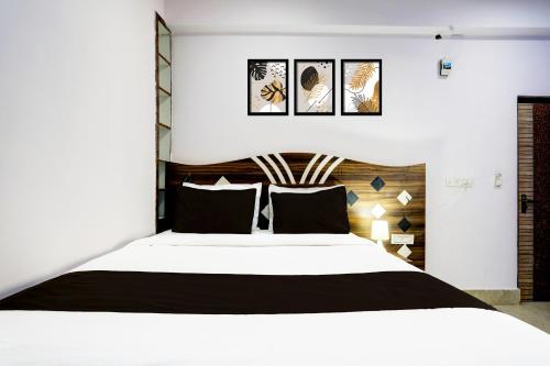 a bedroom with a large bed with black and white sheets at Hotel O Stay Inn in Patna