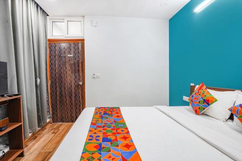 a bedroom with a bed and a blue wall at Hotel RLV Green Palace - Nr Kengeri Satellite Town in Bengaluru
