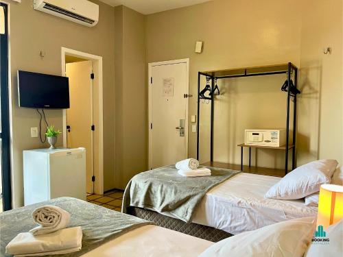 a hotel room with two beds and a television at Golden Flats Beira Mar by Holiday Stays in Fortaleza