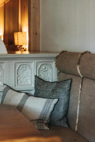 a living room with a couch with pillows at Hotel Berghof in Lech am Arlberg