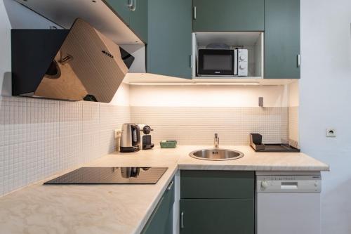 une petite cuisine avec un évier et un micro-ondes dans l'établissement Stylish & Elegant I Metro is only 1minute away I Near Montmartre, à Paris