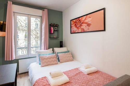 une chambre avec un lit avec des oreillers et une fenêtre dans l'établissement Stylish & Elegant I Metro is only 1minute away I Near Montmartre, à Paris