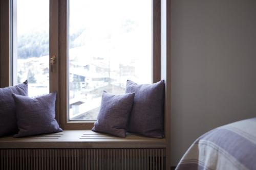 a row of pillows sitting on a window sill at Hotel Berghof in Lech am Arlberg