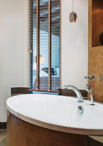 a bath tub in a bathroom with a window at Hotel Berghof in Lech am Arlberg