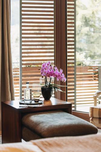 a table with flowers on it in front of a window at Hotel Berghof in Lech am Arlberg