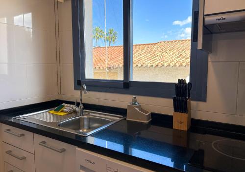 a kitchen counter with a sink and a window at Apartamentos Varadero On the beach in Cala del Moral