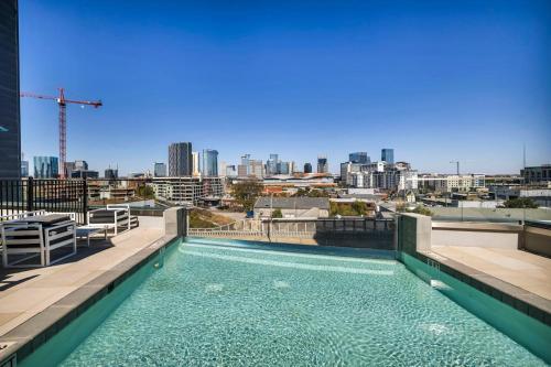 a swimming pool on the roof of a building with a city skyline at The Gulch Music Row Broadway Nashville Parking in Nashville