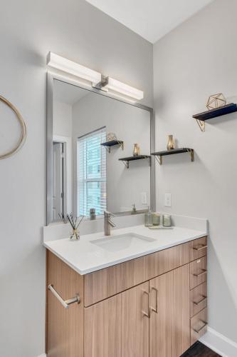 a bathroom with a sink and a large mirror at The Gulch Music Row Broadway Nashville Parking in Nashville