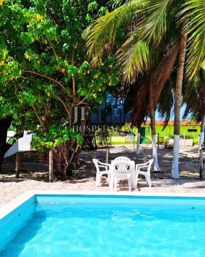 two chairs and a table next to a swimming pool at DST itamaraca in Itamaracá